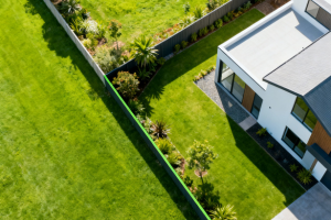 Image of a house sitting amongst a garden of lush green grass. The land is divided into sections.